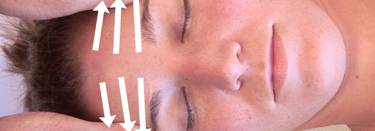 Thumbs on the forehead with three lines indicating the sequence of massage.