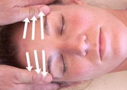 Thumbs on the forehead with three lines indicating the sequence of massage.